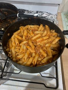 a pan filled with pasta sitting on top of a stove