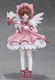 an anime figurine holding a white flower and a pink umbrella on top of a table