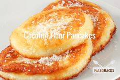 three pancakes on a white plate covered in sauce and powdered sugar with the words coconut flour pancakes