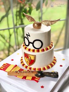 a harry potter themed birthday cake with glasses and wands on the top is ready to be cut