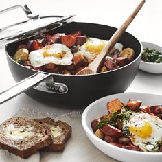 a pan filled with eggs and potatoes next to other food on top of a table