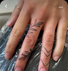 a woman's hand with an arrow tattoo on it