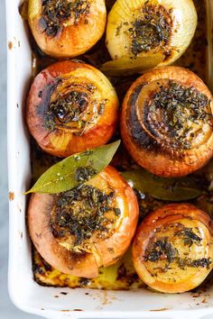 baked potatoes with herbs and seasoning in a casserole dish, ready to be eaten