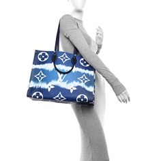 This is an authentic LOUIS VUITTON Monogram Escale Onthego GM in Blue. This limited edition tote features oversized and smaller versions of the classic Louis Vuitton monogram printed in white on a blue tie-dye coated canvas. The bag features dark blue rolled top handles and longer shoulder straps that can be tucked away inside the bag, accented with polished silver hardware. The top is open to a spacious mini monogram printed blue fabric interior with zipper and patch pockets. Monogram Prints, Blue Tie, Blue Tie Dye, Blue Fabric, Authentic Louis Vuitton, Silver Hardware, Louis Vuitton Monogram, Patch Pocket, Shoulder Straps