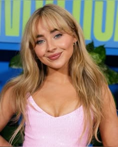 a close up of a person wearing a pink dress and smiling at the camera with her hands on her hips