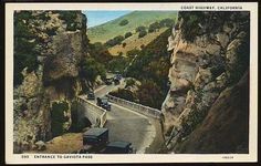 an old postcard with cars driving down the road in front of mountains and cliffs