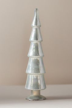 a clear glass christmas tree on a white table