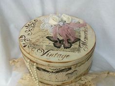 an old fashioned box with pearls and flowers on it's lid is sitting on a white sheet