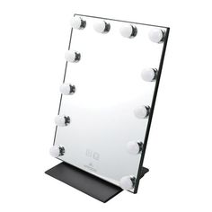 a large mirror with lights on it sitting on top of a table in front of a white background