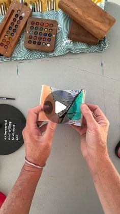 a person is working on an art project with scissors and other items in the background