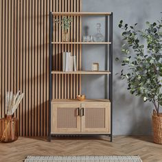 a wooden shelf sitting next to a potted plant on top of a hard wood floor