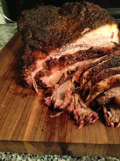 sliced meat sitting on top of a wooden cutting board