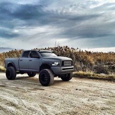 a gray truck parked on top of a dirt road