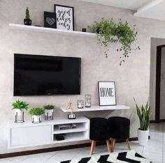 there is a television on the wall in this living room with black and white decor