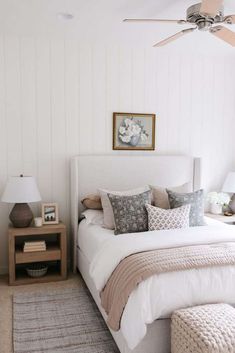 a bedroom with a bed, nightstand and ceiling fan