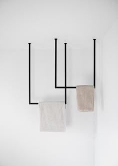 two towels hanging on the wall next to each other in a room with white walls