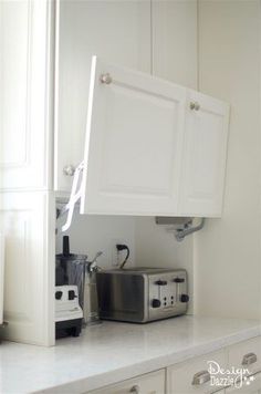 a kitchen with white cabinets and appliances in it