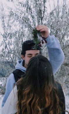 a man holding onto a woman's head in the snow