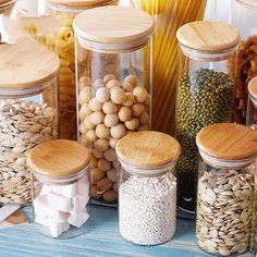 several jars filled with different types of nuts and cereals on top of a blue table