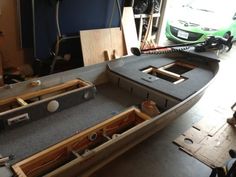 the inside of a boat being built in a garage with tools and other items around it