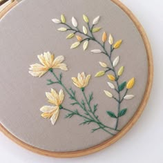 a close up of a embroidery on a piece of cloth with flowers in the middle