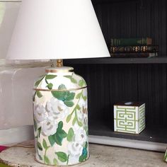 a lamp sitting on top of a table next to a book shelf