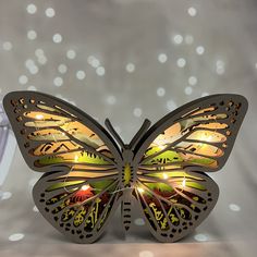 a butterfly shaped light up sculpture with lights on it's wings, sitting in front of a white background