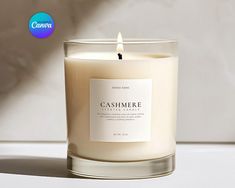 a candle that is sitting on a table next to a white wall and the words cashmere written in it