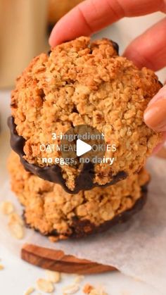 a person holding an oatmeal cookie in their hand