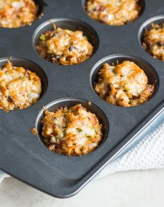 a muffin tin filled with different types of food