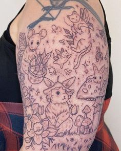 a person with a tattoo on their arm that has animals and mushrooms all over it