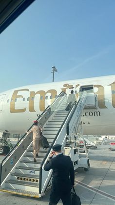 a man walking up the stairs to an airplane