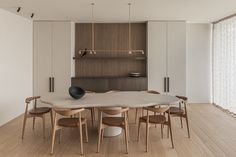 a dining room table and chairs in front of a wall with wooden slats on it