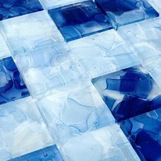 blue and white glass tiles are arranged in an abstract pattern on the floor with water droplets