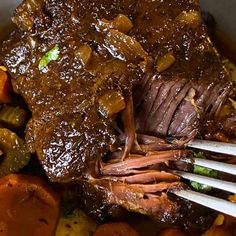 a bowl filled with meat, potatoes and carrots