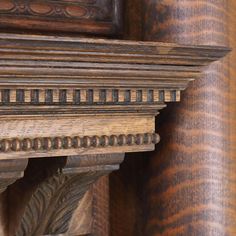 a close up of a wooden shelf with decorative carvings on the top and bottom part