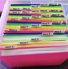 a pink plastic box filled with lots of colorful folders and writing on the side