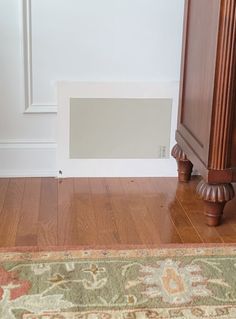 an empty room with wood flooring and a rug on the floor next to it