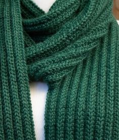 a green knitted scarf on a mannequin