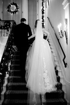 a bride and groom walking down the stairs at their wedding ceremony in black and white