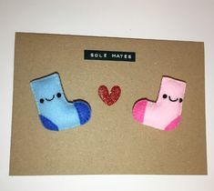 two pairs of socks with hearts on them sitting on top of a piece of cardboard