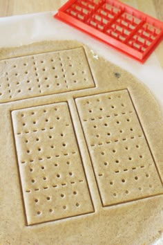 an uncooked pizza sitting on top of a table next to a red grater