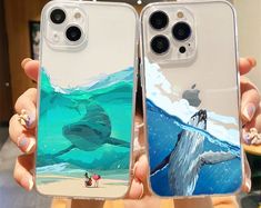 two people holding up their iphone cases with paintings on them in the shape of animals