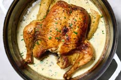 a close up of a chicken in a pot with gravy on the side