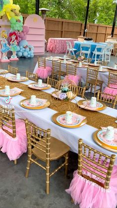 a table set up for a princess birthday party with pink and gold plates, napkins, cups, and cake