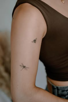 a woman with a small tattoo on her left arm and the other arm behind her