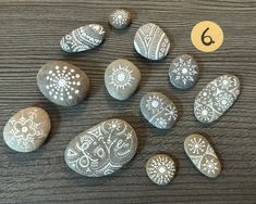 some rocks are sitting on a table with the numbers six and six painted on them