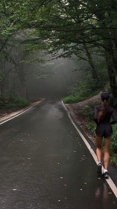 a woman running down the road in the rain