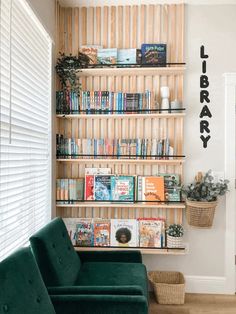 a green couch sitting in front of a book shelf filled with books