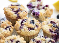 blueberry muffins on a cooling rack with lemon wedges in the background